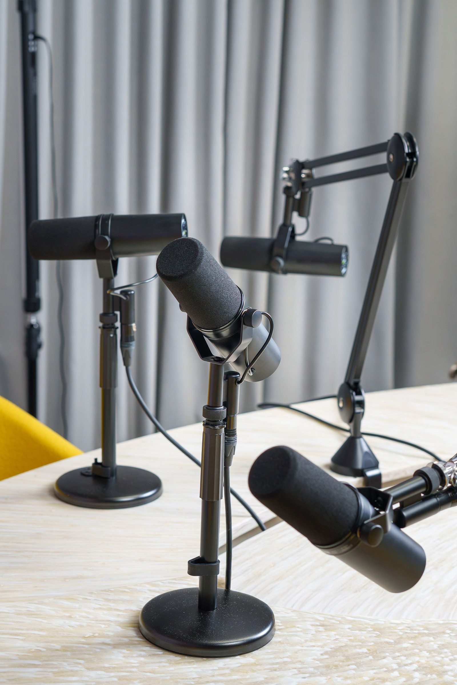 Microphones on boom arms in a podcast studio